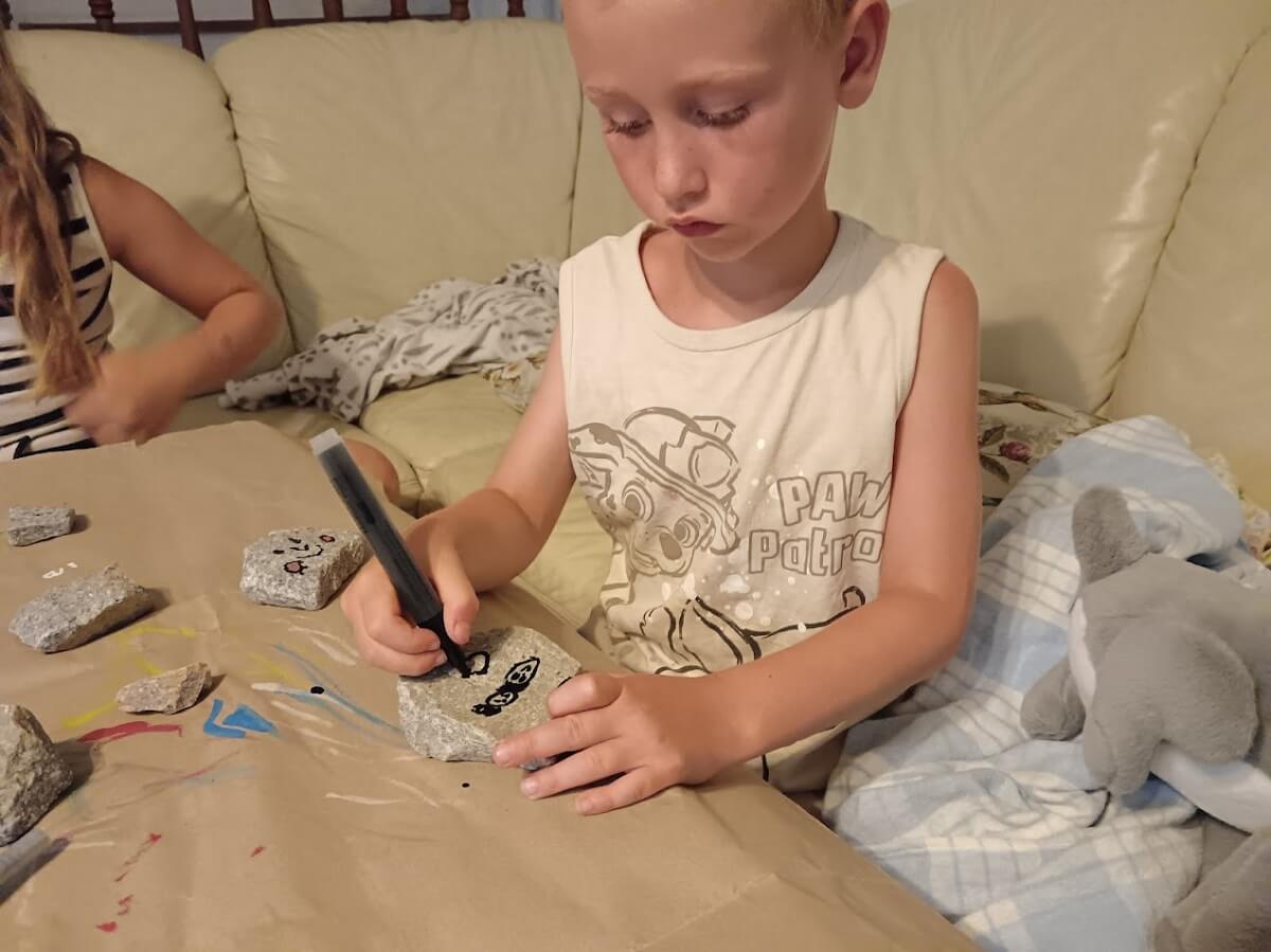Chlapeček si maluje na kamínek s fixami od Artmagico